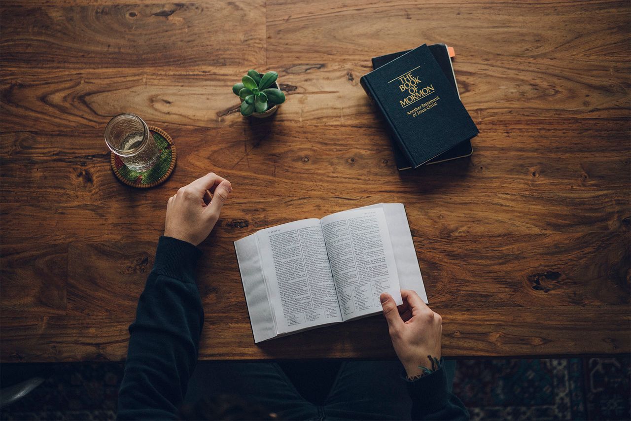 Mężczyzna studiuje Biblię i Księgę Mormona przy kuchennym stole