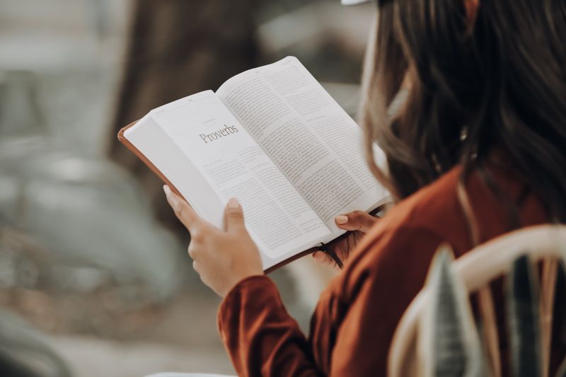 Kobieta czyta Przypowieści Salomona w Biblii